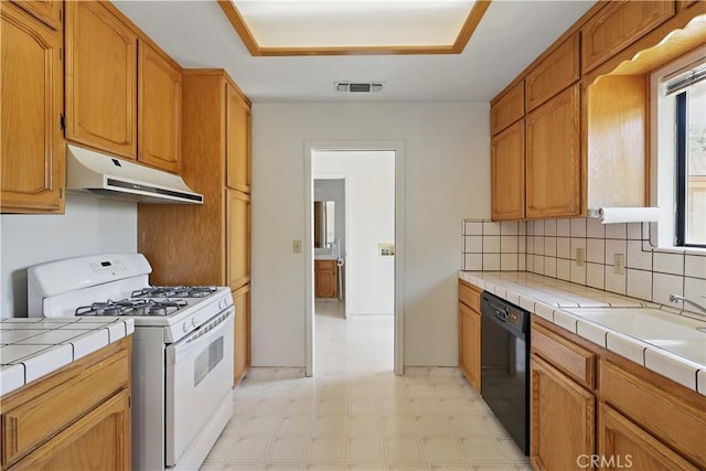 442 R St, Merced, CA 95341 - kitchen with gas range gas stove, under cabinet range hood, black dishwasher, tile countertops, and light floors