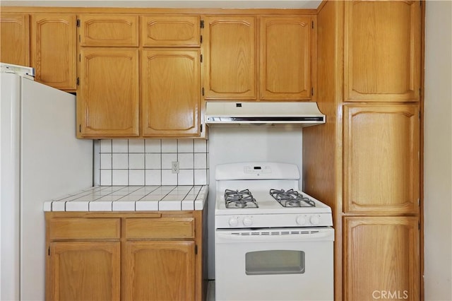 442 R St, Merced, CA 95341 - kitchen with white appliances, under cabinet range hood, tile counters, and decorative backsplash
