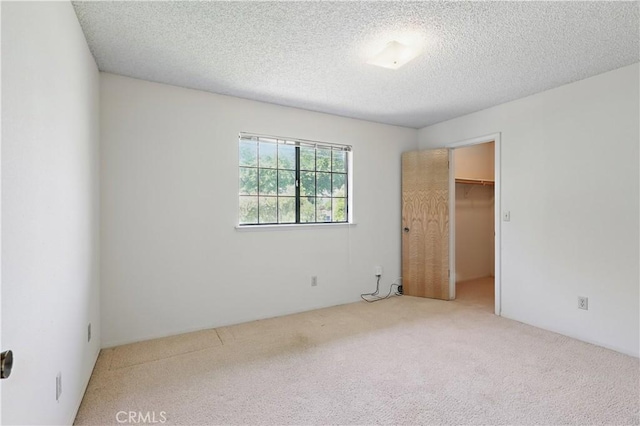 442 R St, Merced, CA 95341 - unfurnished bedroom featuring carpet flooring, a spacious closet, a textured ceiling, and a closet