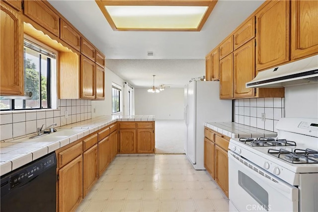 442 R St, Merced, CA 95341 - kitchen featuring white appliances, under cabinet range hood, tile countertops, a sink, and backsplash