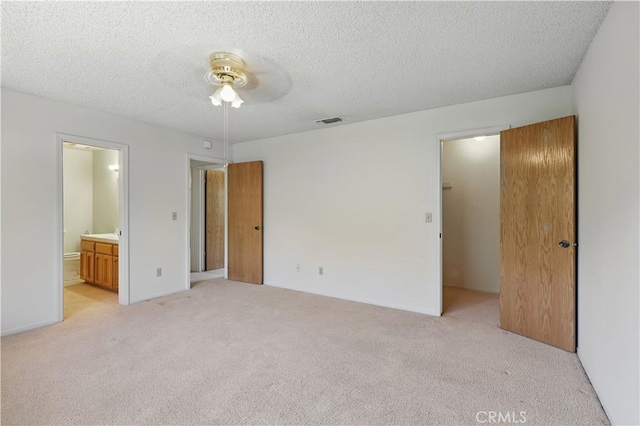 442 R St, Merced, CA 95341 - unfurnished bedroom featuring light colored carpet, a textured ceiling, ensuite bathroom, and ceiling fan