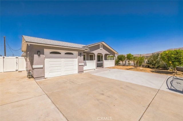 15025 Avenida Ramada, Desert Hot Springs, CA 92240 - ranch-style house featuring a gate, concrete driveway, an attached garage, and stucco siding