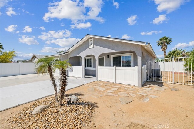 15025 Avenida Ramada, Desert Hot Springs, CA 92240 - view of front of house featuring stucco siding, fence, driveway, and an attached garage