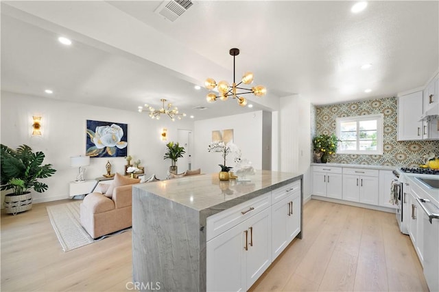 13112 Palomar St, Westminster, CA 92683 - kitchen with a chandelier, light stone countertops, light wood-style flooring, recessed lighting, and stainless steel stove