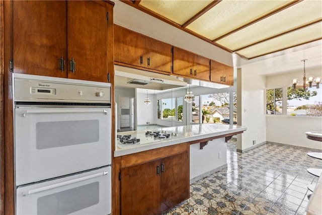2021 Elanita Dr, San Pedro, CA 90732 - kitchen with a chandelier, white appliances, tile counters, tile patterned floors, and brown cabinetry