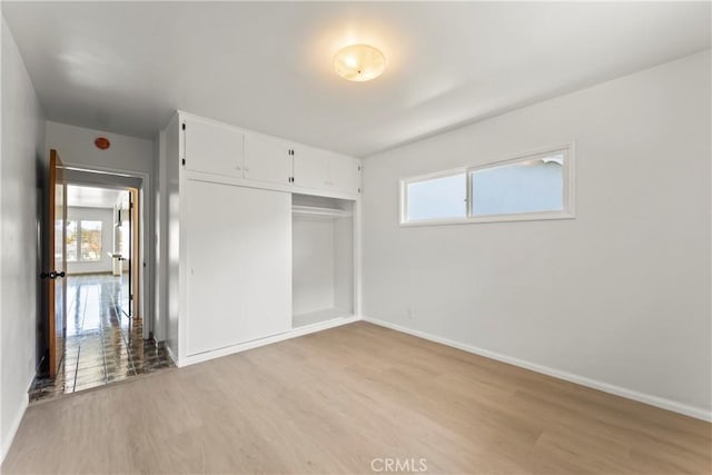 2021 Elanita Dr, San Pedro, CA 90732 - unfurnished bedroom with multiple windows, light wood-style floors, and baseboards