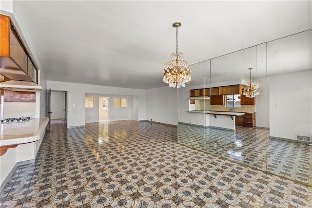 2021 Elanita Dr, San Pedro, CA 90732 - kitchen featuring a chandelier, open floor plan, baseboards, pendant lighting, and brown cabinetry
