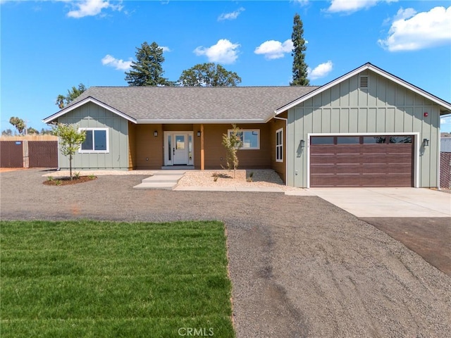 ranch-style house with board and batten siding, a garage, roof with shingles, driveway, and fence
