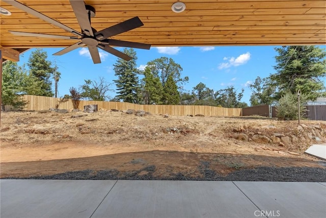 view of yard with ceiling fan and fence