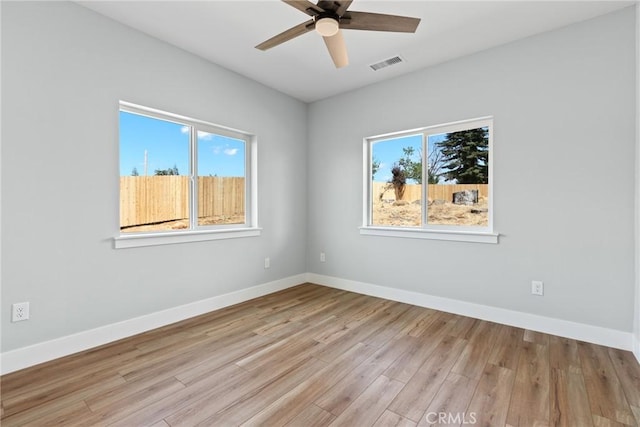 spare room with a ceiling fan, wood finished floors, and baseboards