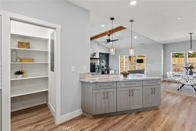 kitchen featuring gray cabinetry, light wood-style floors, a ceiling fan, baseboards, and lofted ceiling