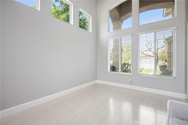 2 Corte Lateuza, Lake Elsinore, CA 92532 - empty room featuring plenty of natural light, baseboards, a towering ceiling, and wood finished floors