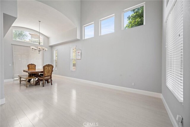 2 Corte Lateuza, Lake Elsinore, CA 92532 - dining room with healthy amount of natural light, light wood-style floors, a chandelier, baseboards, and a high ceiling