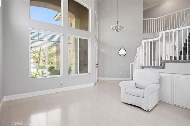 2 Corte Lateuza, Lake Elsinore, CA 92532 - living area featuring stairway, baseboards, a chandelier, a high ceiling, and light wood-type flooring