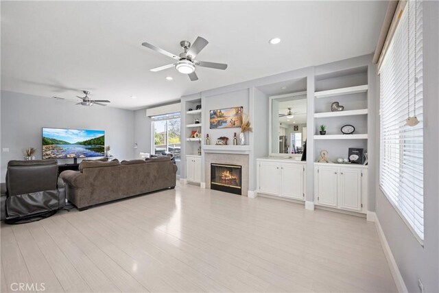 2 Corte Lateuza, Lake Elsinore, CA 92532 - living room with ceiling fan, a glass covered fireplace, built in features, light wood finished floors, and recessed lighting