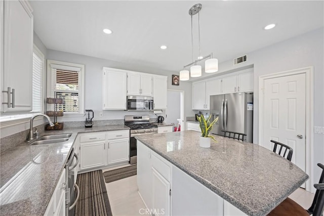 2 Corte Lateuza, Lake Elsinore, CA 92532 - kitchen with appliances with stainless steel finishes, a sink, a kitchen island, recessed lighting, and white cabinets