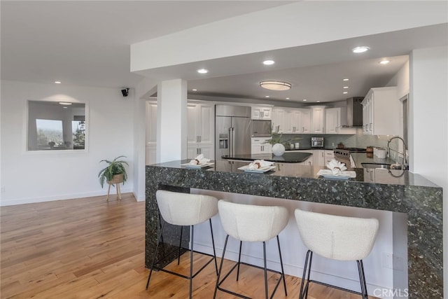 3828 Alomar Dr, Sherman Oaks, CA 91423 - kitchen featuring premium appliances, a sink, wall chimney range hood, a breakfast bar, and recessed lighting