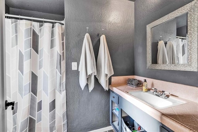 56772 Kismet Rd, Yucca Valley, CA 92284 - bathroom with a textured wall, curtained shower, vanity, and baseboards