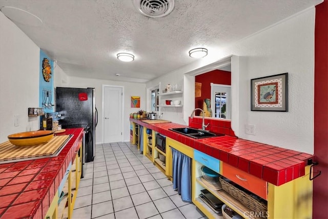 56772 Kismet Rd, Yucca Valley, CA 92284 - kitchen with a sink, tile countertops, a textured ceiling, black appliances, and open shelves