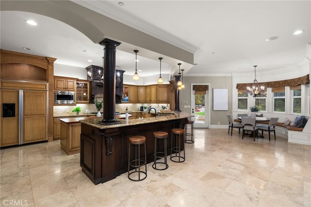475 W 26th St, Upland, CA 91784 - kitchen with built in appliances, a kitchen bar, brown cabinets, backsplash, and ornamental molding
