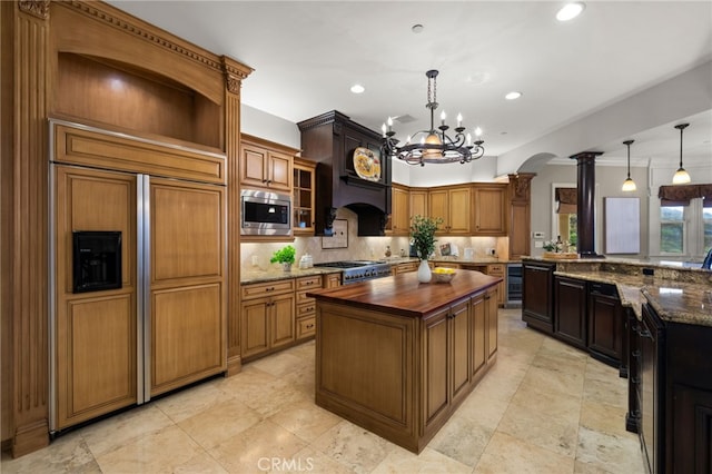 475 W 26th St, Upland, CA 91784 - kitchen with built in appliances, arched walkways, wood counters, decorative columns, and backsplash