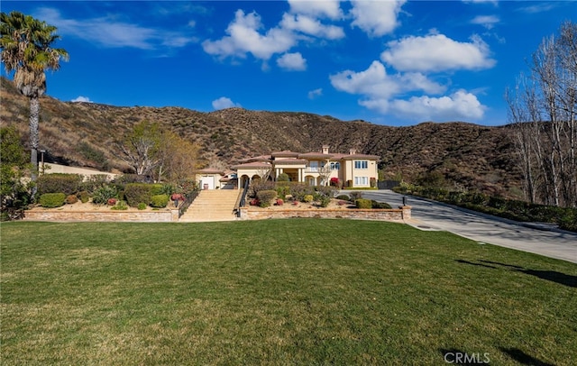 475 W 26th St, Upland, CA 91784 - view of front of house featuring driveway, a mountain view, a front lawn, and an attached garage