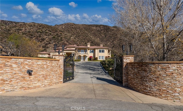 475 W 26th St, Upland, CA 91784 - view of front of house with a gate, a mountain view, and a chimney