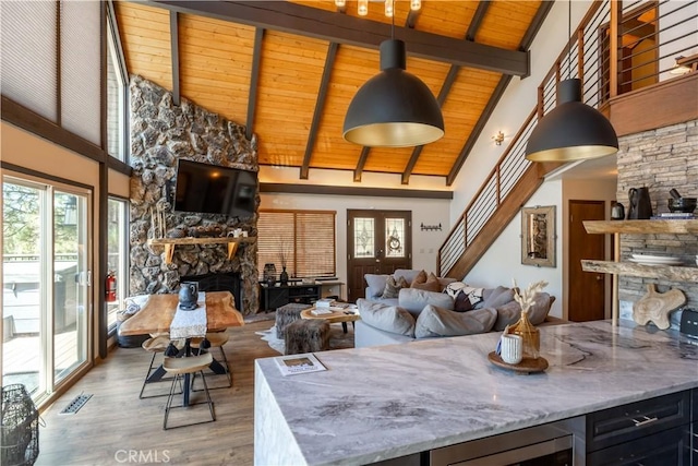 43620 Colusa Dr, Big Bear Lake, CA 92315 - living room with a fireplace, wood finished floors, beamed ceiling, plenty of natural light, and wooden ceiling