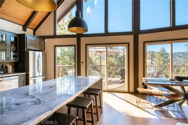 43620 Colusa Dr, Big Bear Lake, CA 92315 - dining space with healthy amount of natural light, high vaulted ceiling, beam ceiling, wood finished floors, and wooden ceiling