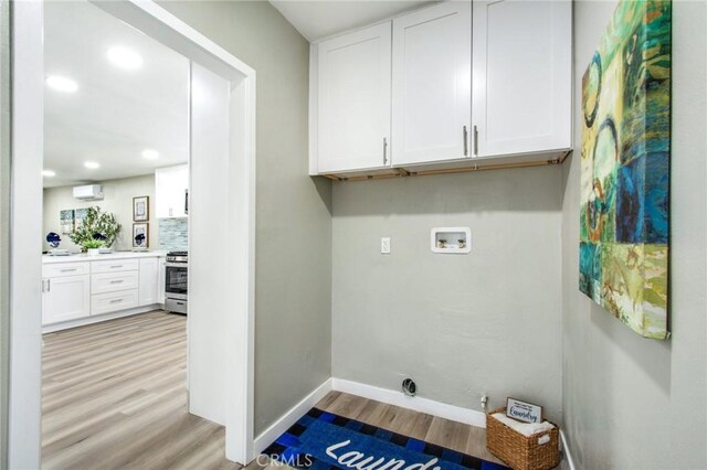 14907 S Raymond Ave, Gardena, CA 90247 - laundry room with light wood-type flooring, hookup for a washing machine, a wall unit AC, cabinet space, and recessed lighting