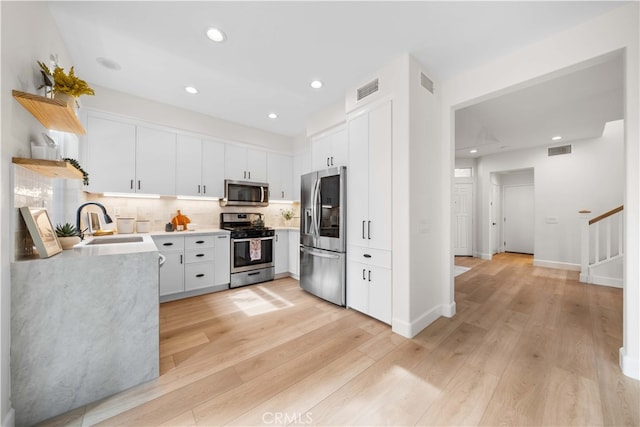 59 Cape Victoria, Aliso Viejo, CA 92656 - kitchen featuring appliances with stainless steel finishes, a sink, open shelves, light countertops, and decorative backsplash