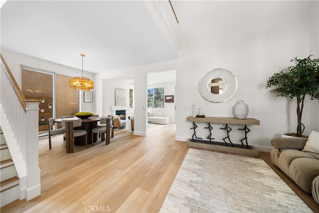 59 Cape Victoria, Aliso Viejo, CA 92656 - living area with stairway, light wood finished floors, a lit fireplace, and baseboards