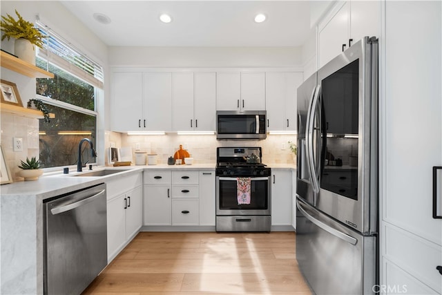 59 Cape Victoria, Aliso Viejo, CA 92656 - kitchen with stainless steel appliances, a sink, light countertops, decorative backsplash, and white cabinetry