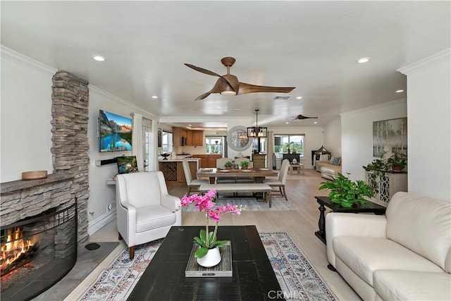 2546 N Orange Hill Ln, Orange, CA 92867 - living room featuring ceiling fan, crown molding, a stone fireplace, recessed lighting, and light wood-type flooring