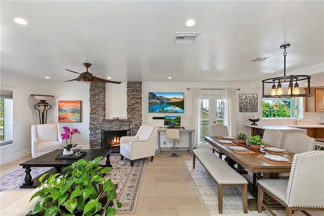 2546 N Orange Hill Ln, Orange, CA 92867 - dining room featuring a stone fireplace, crown molding, light wood-style flooring, recessed lighting, and ceiling fan