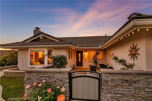 2546 N Orange Hill Ln, Orange, CA 92867 - view of front facade with a gate, a chimney, stucco siding, and stone siding