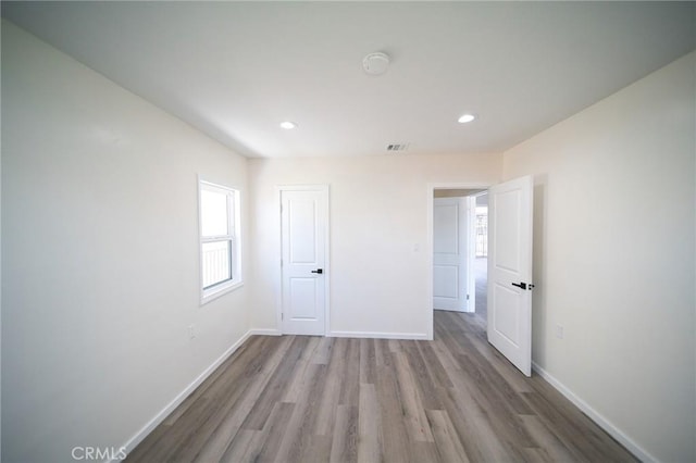 1336 W 118th St, Los Angeles, CA 90044 - unfurnished bedroom with wood finished floors, baseboards, and recessed lighting