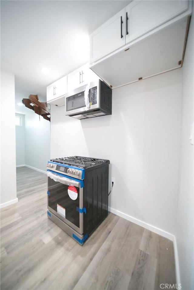 1336 W 118th St, Los Angeles, CA 90044 - kitchen featuring stainless steel appliances, light wood-type flooring, baseboards, and white cabinets