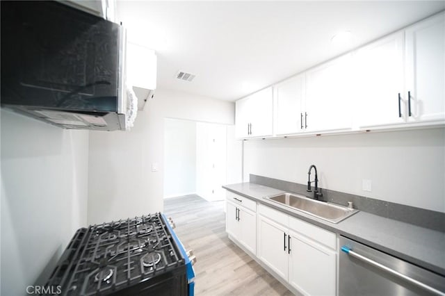 1336 W 118th St, Los Angeles, CA 90044 - kitchen with a sink, stainless steel dishwasher, light wood finished floors, and white cabinets