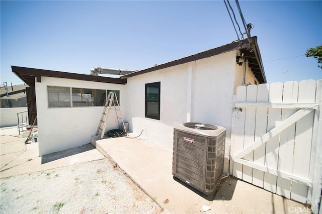 1336 W 118th St, Los Angeles, CA 90044 - rear view of house with central AC unit, stucco siding, a gate, and a patio