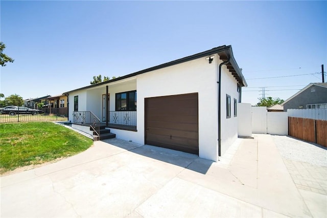 1336 W 118th St, Los Angeles, CA 90044 - view of front of home featuring stucco siding, an attached garage, driveway, and a porch
