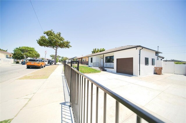 1336 W 118th St, Los Angeles, CA 90044 - view of front of house featuring stucco siding, an attached garage, and concrete driveway