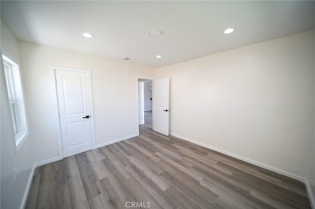 1336 W 118th St, Los Angeles, CA 90044 - unfurnished bedroom with wood finished floors, baseboards, and recessed lighting