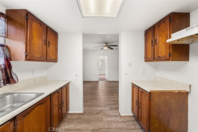368 W St, Upland, CA 91786 - kitchen featuring light wood-style floors, a ceiling fan, light countertops, brown cabinetry, and under cabinet range hood