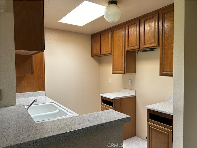 4499 Via Marisol Unit 327, Los Angeles, CA 90042 - kitchen featuring brown cabinets, a skylight, and light countertops