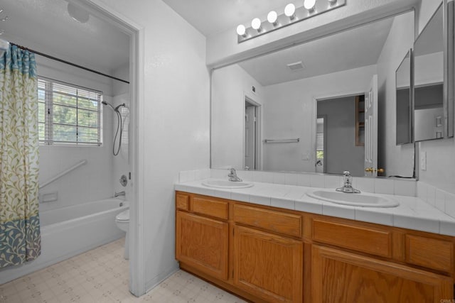 bathroom featuring tile patterned floors, toilet, double vanity, and shower / bath combo with shower curtain