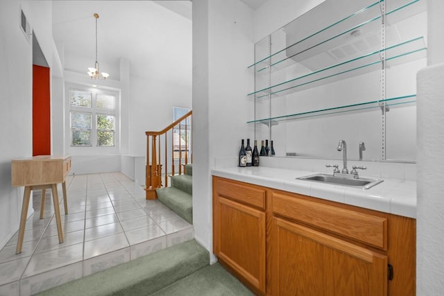 indoor wet bar featuring stairway, light tile patterned flooring, baseboards, and hanging light fixtures