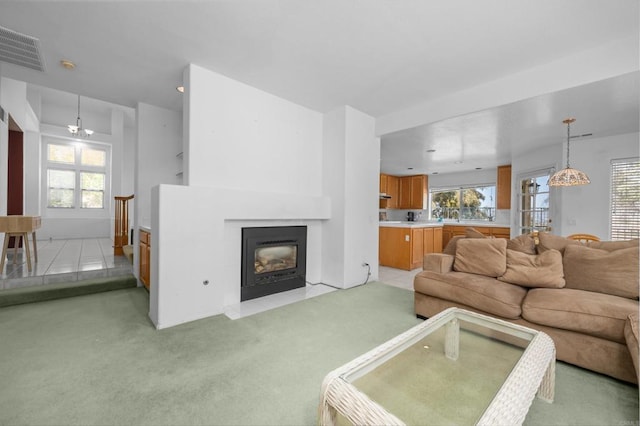 living area featuring light carpet, a fireplace with flush hearth, and healthy amount of natural light