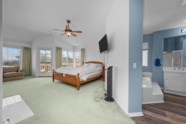 bedroom featuring lofted ceiling, multiple windows, baseboards, a sink, and carpet