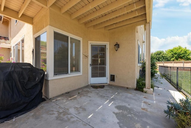 view of patio featuring fence and a grill